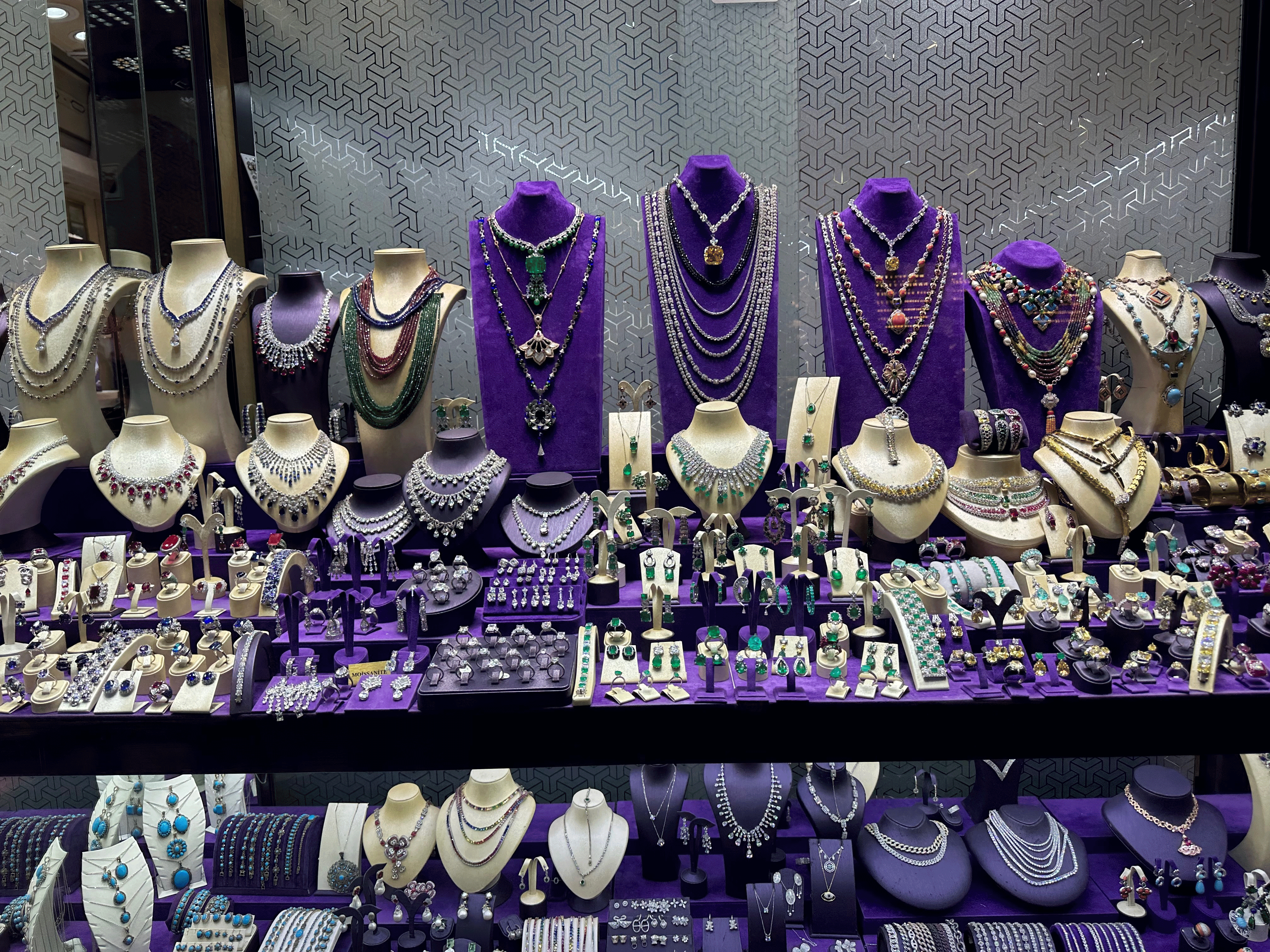 Display of assorted jewelry including necklaces, bracelets, and rings in a jewelry store.